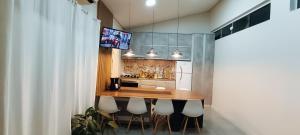 a kitchen with a wooden counter with chairs around it at Casa familiar - Refúgio Climatizado in Florianópolis