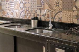 eine Küchentheke mit zwei Waschbecken und einem Wasserhahn in der Unterkunft Kanoas Suites in São José da Coroa Grande + 132 Fotos