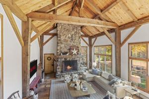 a large living room with a stone fireplace at Modern Lux Cabin w Mtn Views and Fire Pit in Stratton