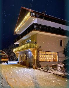 ein Haus mit Weihnachtslichtern im Schnee in der Unterkunft Agroturystyka Górski Wypoczynek in Stryszawa