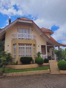 una casa amarilla con techo en Recanto Do Charão, en Gramado