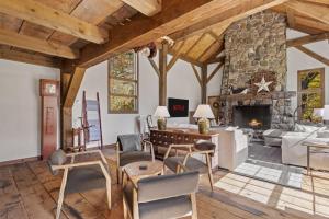a living room with a large stone fireplace at Modern Lux Cabin w Mtn Views and Fire Pit in Stratton