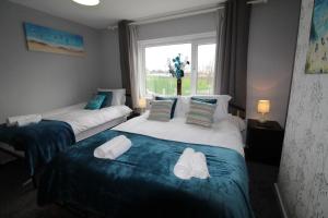 two beds in a room with a window at Richmond House in Sheffield