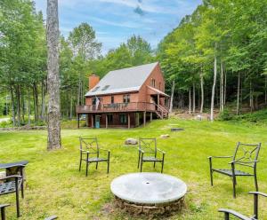 a house with a table and chairs in front of it at Cozy Villager Chalet w Mountain Views and Firepit in Dover