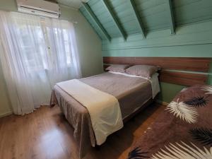 Un dormitorio con una cama y una pared verde. en Recanto Do Charão, en Gramado