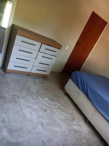 a bedroom with a bed and a dresser at Casa da Andressa in Conceição da Barra