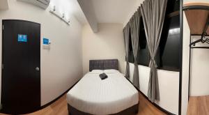 una camera da letto con un letto in una stanza di Sofu Inn a Jelutong