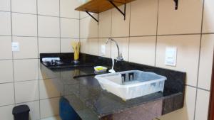 eine Küche mit einem Waschbecken und einem Wasserhahn in der Unterkunft Villa Colibri Barra de São Miguel. in Barra de São Miguel + 47 Fotos