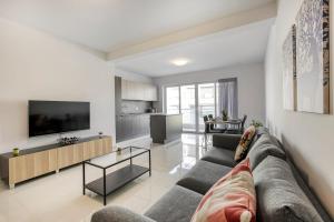 un soggiorno con un divano e una TV di Beautiful Modern Central 2br Apt a Taʼ Xbiex