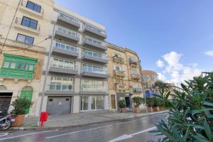an apartment building on a city street with plants at Beautiful Modern Central 2br Apt in Taʼ Xbiex
