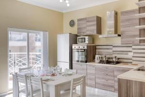 kuchnia z białym stołem i krzesłami oraz kuchnia z kuchnią w obiekcie Seaview,beautiful 3br Apt 3 w mieście Marsaskala