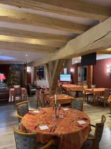 a dining room with wooden tables and chairs at Hotel Le Bon Laboureur in La Charité-sur-Loire