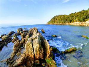 a group of rocks in the water on a beach at Mar Azul A&K - Sol e Mar in Penha