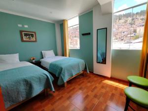 a bedroom with two beds and a large window at Catag Wasi Casa hospedaje in Cajamarca