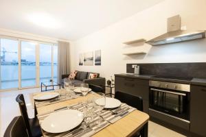 a kitchen and dining room with a table and chairs at Beautiful Central Penthouse 1BR in Taʼ Xbiex