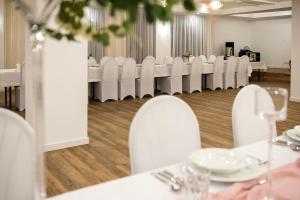 a dining room with white tables and white chairs at Jawja Przystań Gościnności in Rzemień