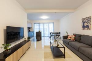 a living room with a couch and a flat screen tv at Beautiful Modern Central 2BR Apt in Taʼ Xbiex