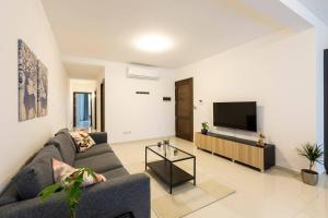 a living room with a couch and a flat screen tv at Beautiful Modern Central 2BR Apt in Taʼ Xbiex