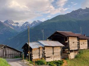 a group of wooden buildings on a hill with mountains at Chalet Bel Horizon in Saint-Martin
