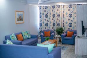 a living room with two blue couches and a table at Durban Beachfront Bliss in Durban