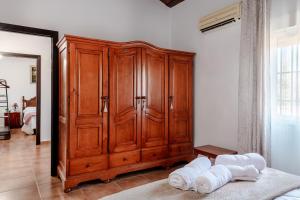 een grote houten kast in een slaapkamer met handdoeken op de vloer bij Casa rural con piscina, barbacoa, aire acondicionado, WiFi de alta velocidad, cocina exterior y Parking in Córdoba +46 foto's