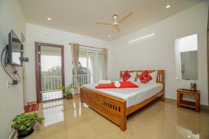 a bedroom with a bed with red pillows on it at Shola Gardens , Kotagiri in Kotagiri