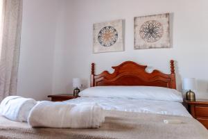 een slaapkamer met een bed en twee schilderijen aan de muur bij Casa rural con piscina, barbacoa, aire acondicionado, WiFi de alta velocidad, cocina exterior y Parking in Córdoba