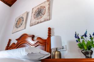 een slaapkamer met een bed en twee schilderijen aan de muur bij Casa rural con piscina, barbacoa, aire acondicionado, WiFi de alta velocidad, cocina exterior y Parking in Córdoba