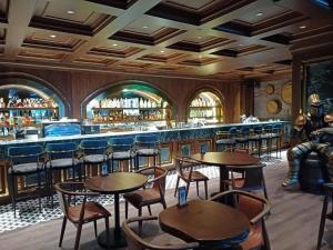 Un bar con mesas y sillas en un restaurante. en Grand Sapphire Deluxe Residances, en Saint Yeorgios