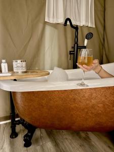 a person holding a glass of wine in a bath tub at Piney River Resort in Bon Aqua