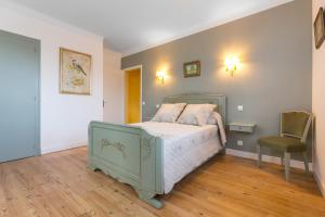 a bedroom with a green bed and a chair at Appartements - Chez Alice in Salies-de-Béarn