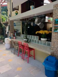 a group of red chairs sitting at a counter at Coyaba Tropical Elegant Adult Guesthouse in Manuel Antonio