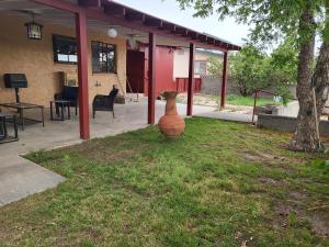 a vase sitting in the grass in front of a house at Top of the Hill Guest House in Truth or Consequences