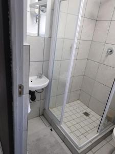 un baño con ducha y lavabo en Grace Villas 6, en East London