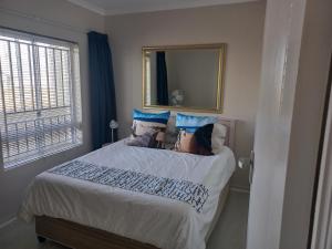 a bedroom with a large bed with a mirror at 215 Sea View in Cape Town +10 photos
