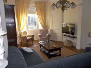 a living room with a blue couch and a tv at Villa Angel - SPA in Caunes-Minervois