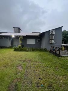 a house with a grass yard in front of it at Casa familiar - Refúgio Climatizado in Florianópolis