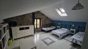 a bedroom with two beds and a stone wall at Casa Bezales en Ampuero Cantabria in Ampuero +32 photos