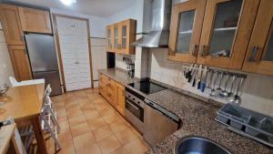 a kitchen with wooden cabinets and a stove top oven at Casa Bezales en Ampuero Cantabria in Ampuero