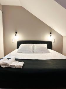 ein Bett mit weißer Bettwäsche und zwei Handtüchern darauf in der Unterkunft Chambre privée "Graine de Coton" - Cuisine partagée in Amiens