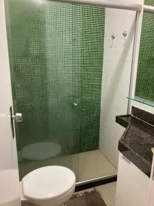 a bathroom with a toilet and a glass shower at Flat Recanto Monte Castelo - Gravatá in Sairé