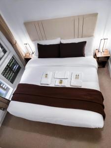 a bedroom with a large white bed with two plates on it at Luxury 2-Bedroom London Apartment, 25mins to Liverpool Street, Balcony, Free Parking in London