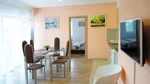 a dining room with a table and chairs and a television at Apartments Bramar in Zlatibor +37 photos