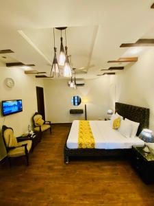 a hotel room with a bed and two chairs at Harvey's Guest House in Islamabad