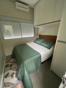 a small bedroom with a bed and a window at Casa familiar - Refúgio Climatizado in Florianópolis