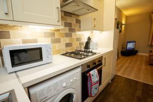a kitchen with a microwave and a stove at Modern Spacious 2 Bed Apartment Wolverhampton with Free Secure Parking in Wolverhampton