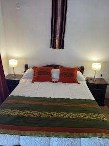 a bedroom with a bed with two lamps on two tables at El Descanso Cafayate in Cafayate