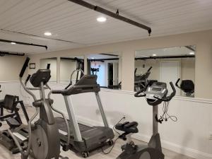 a gym with three exercise bikes and mirrors at Edgewater Beach Resort in Dennis Port
