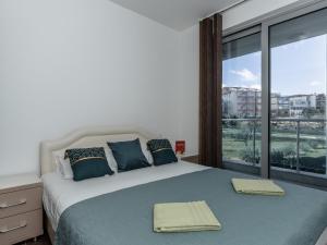a bedroom with a bed with a large window at Apartments 4U in Dobra Voda