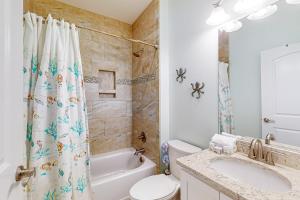 a bathroom with a sink and a toilet and a tub at Mermaid Manor in Mexico Beach +18 photos